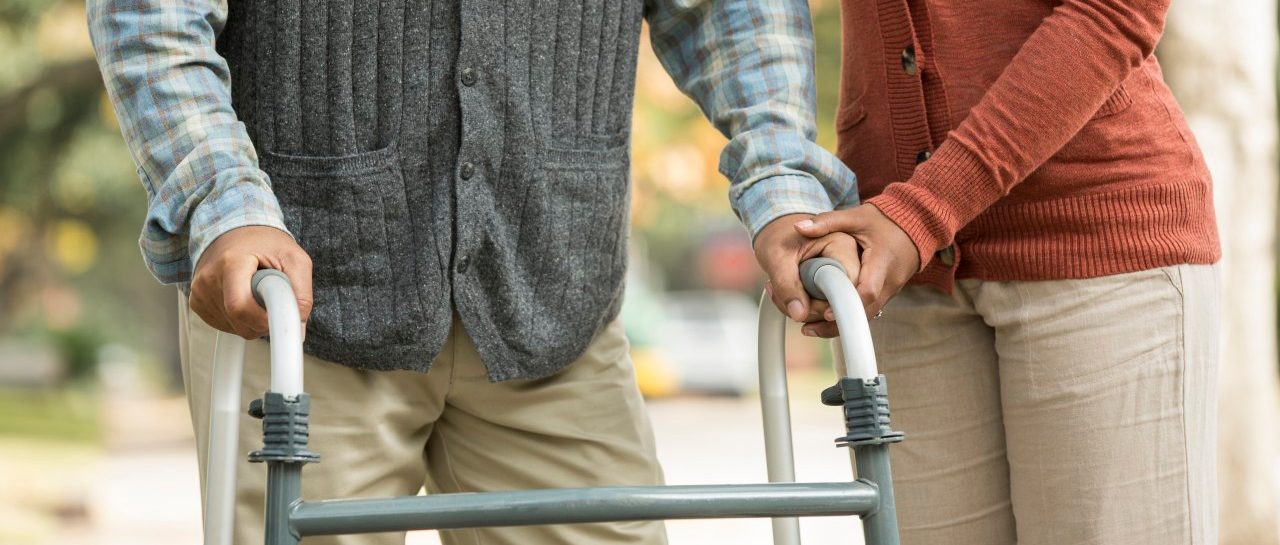 04 Dec 2013 --- African American woman helping father use walker --- Image by © Terry Vine/Blend Images/Corbis