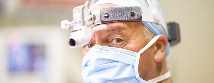 Surgeon wearing mask and headlamp --- Image by Â© Zero Creatives/cultura/Corbis