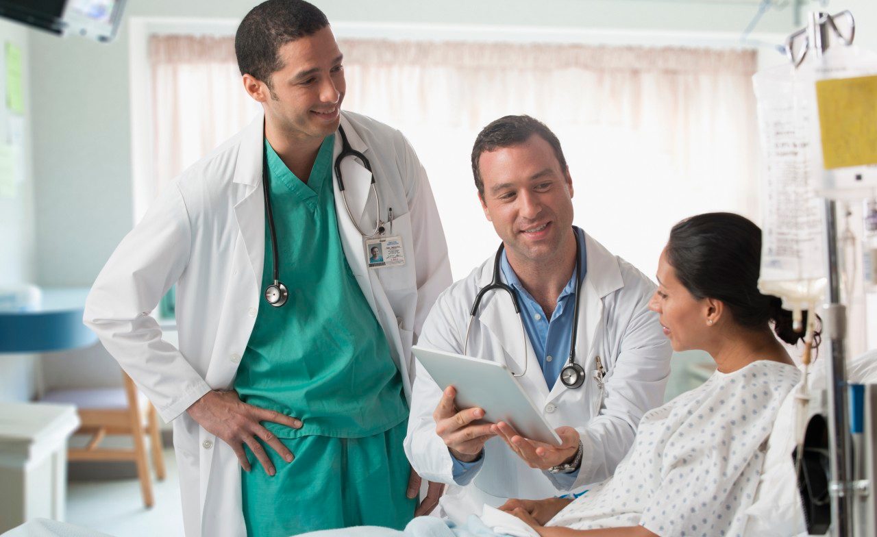 22 Jul 2013 --- Doctor and nurse talking to patient in hospital --- Image by © Jose Luis Pelaez Inc/Blend Images/Corbis