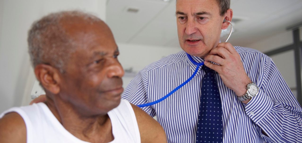 Doctor with stethoscope with elderly man --- Image by © Janie Airey/cultura/Corbis