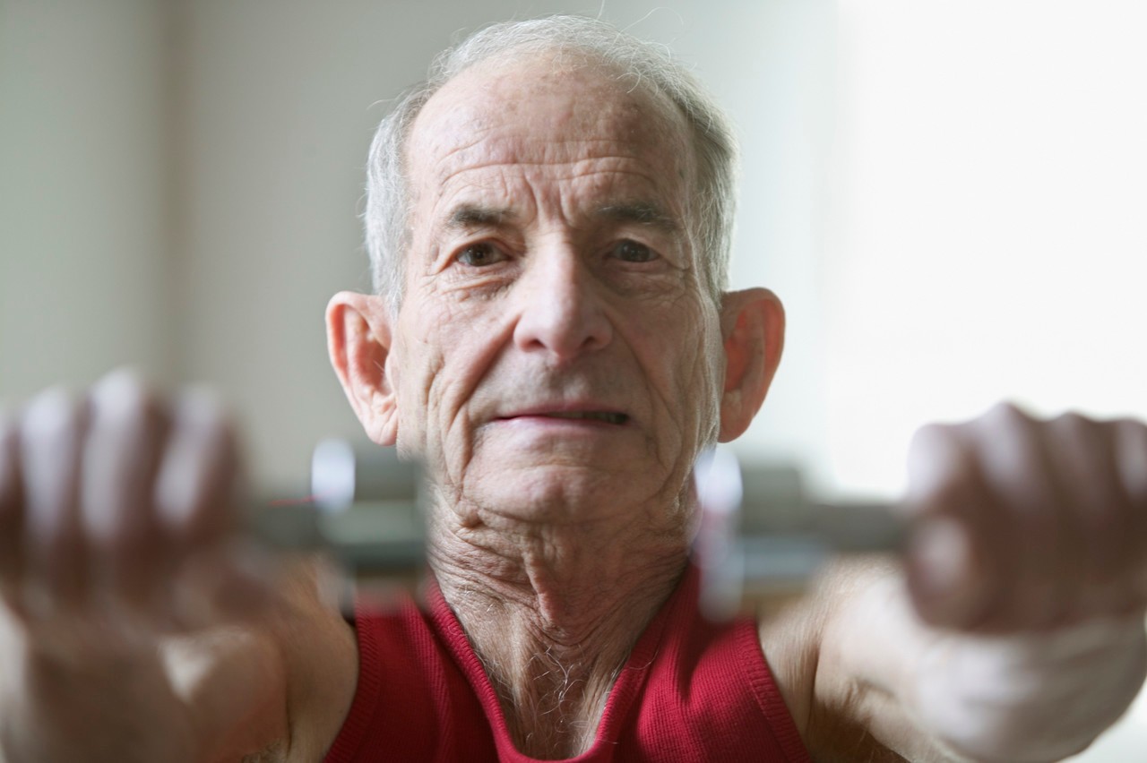 Portrait of elderly man lifting weights --- Image by © Jose Luis Pelaez, Inc./Blend Images/Corbis