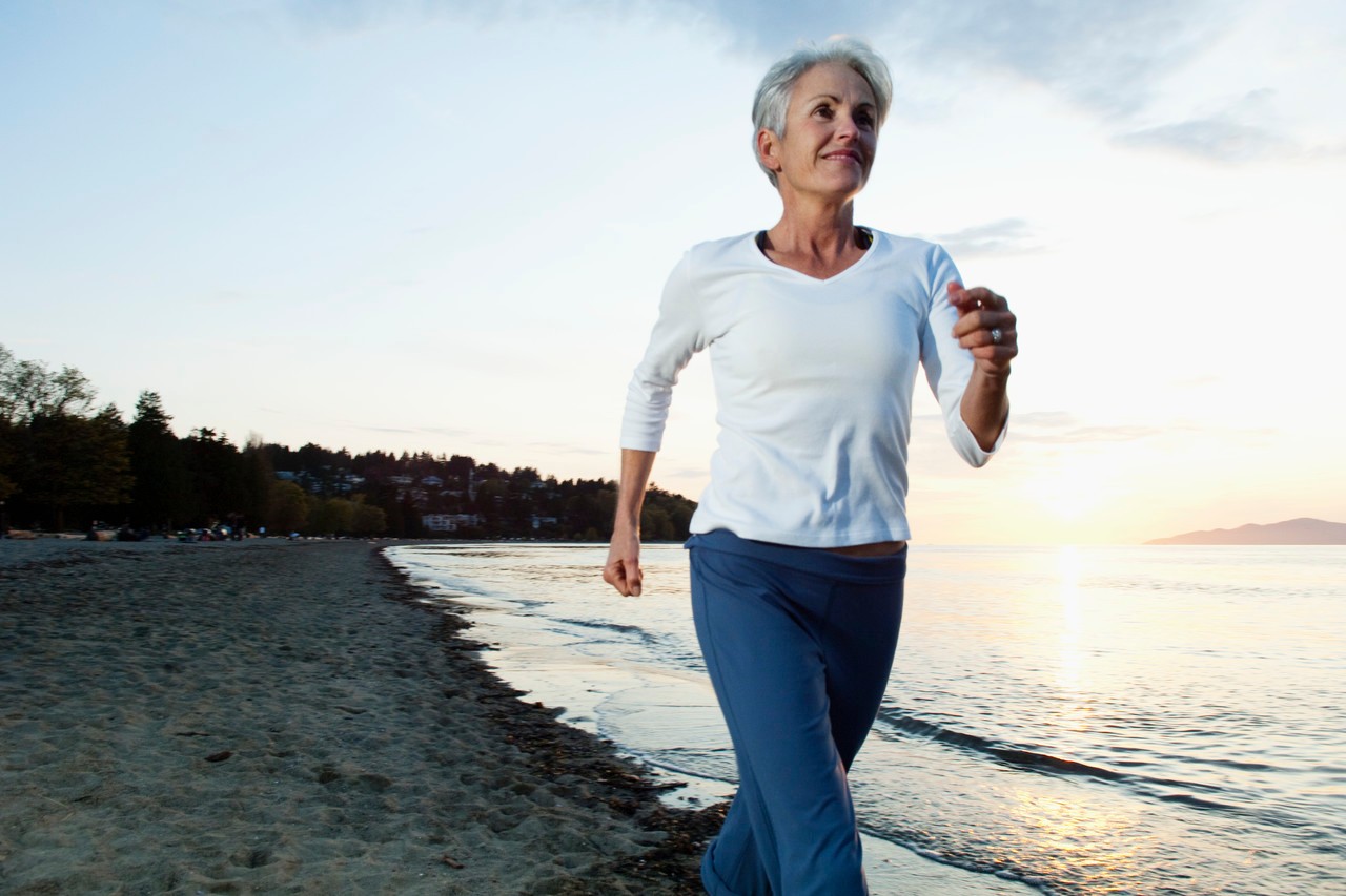 Woman running on beach --- Image by © Monalyn Gracia/Corbis