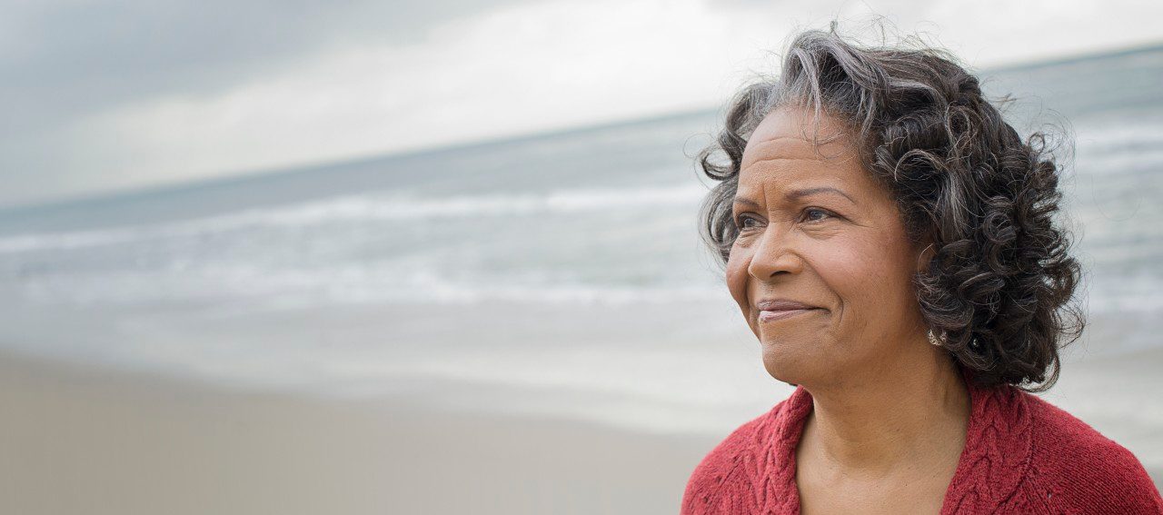 Portrait of elderly woman on beach --- Image by © Hiya Images/Corbis