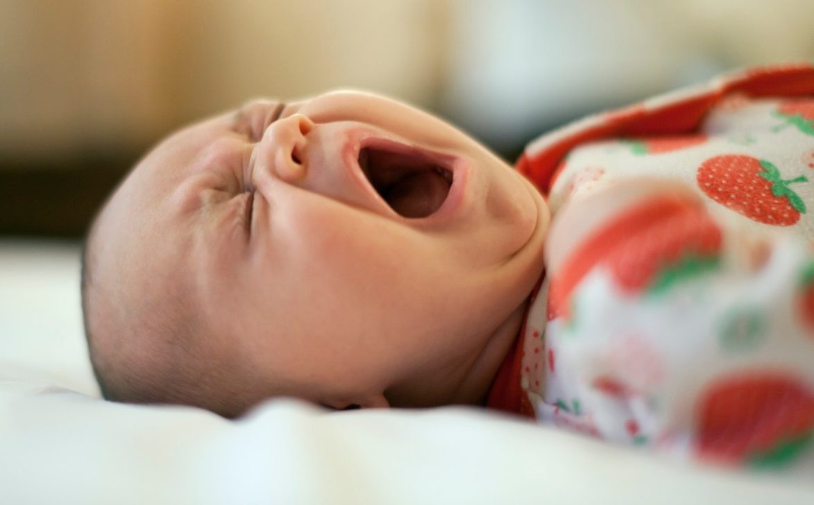 Two month old baby lying down yawning --- Image by © MKeal/Corbis