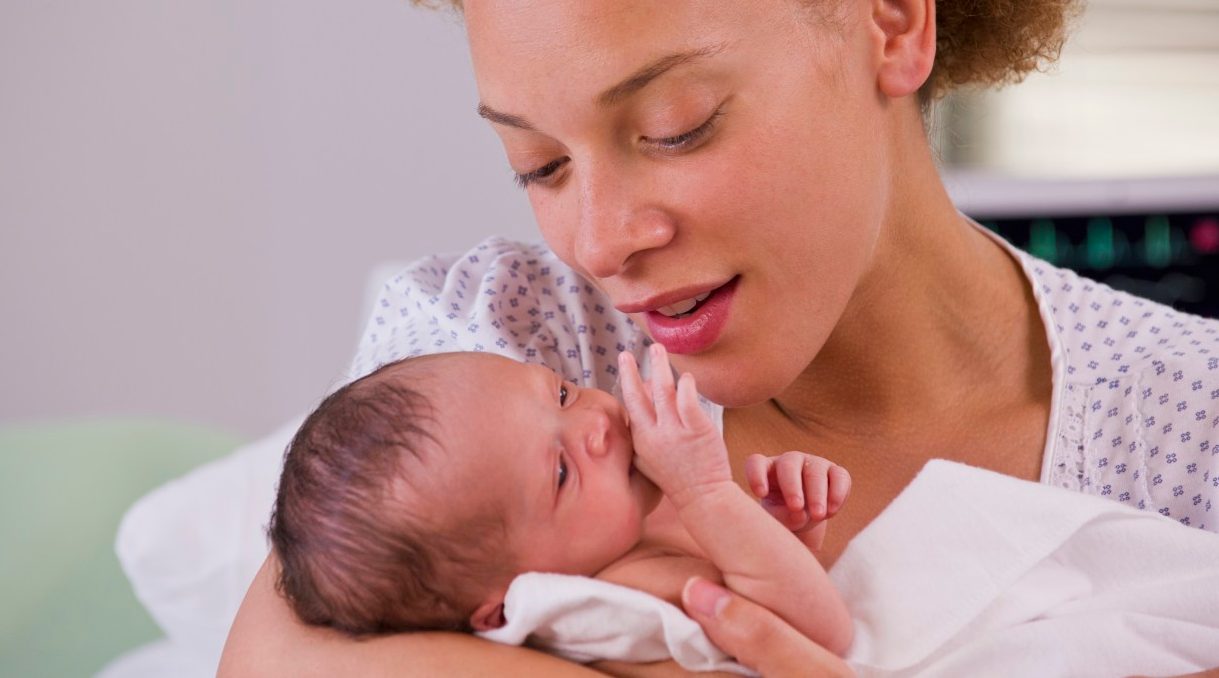 01 Jun 2012, Richmond, Virginia, USA --- Mixed race mother holding newborn baby --- Image by © Ariel Skelley/Blend Images/Corbis