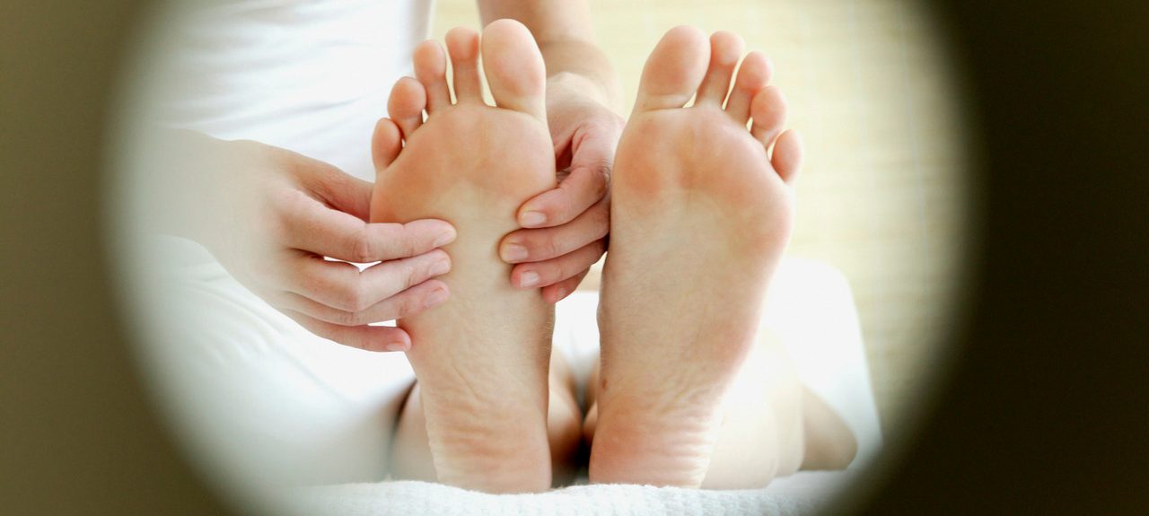 Masseuse massaging woman's feet --- Image by © Ralf Schultheiss/Corbis