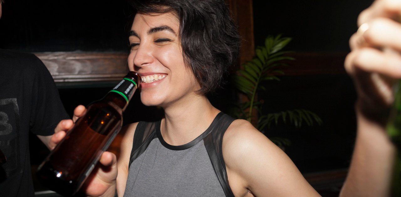 16 Aug 2014 --- Young woman enjoying a beer at a party --- Image by © HEX/Corbis