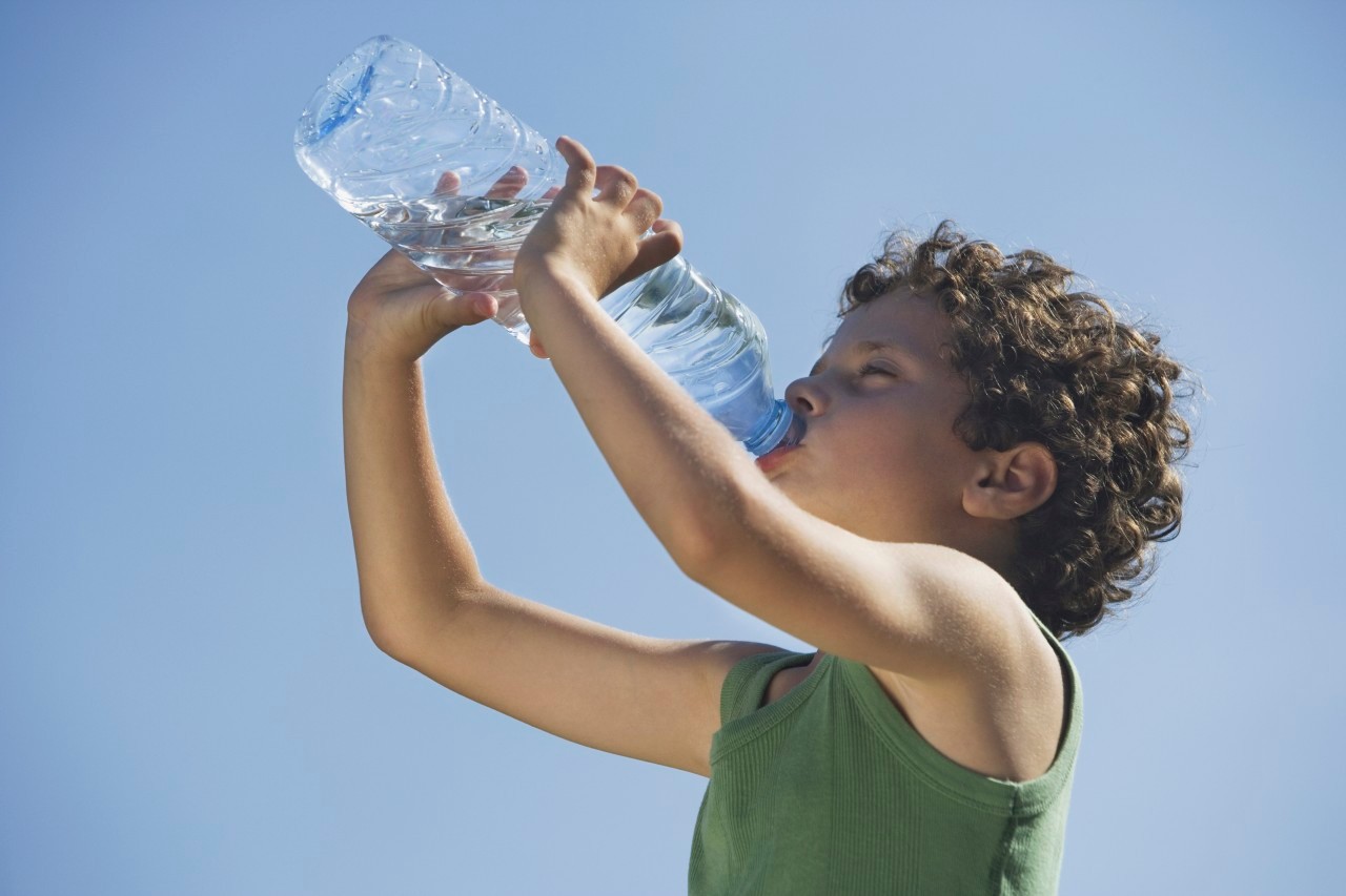 Low angle of young boy drinking water --- Image by © Steve Sparrow/cultura/Corbis