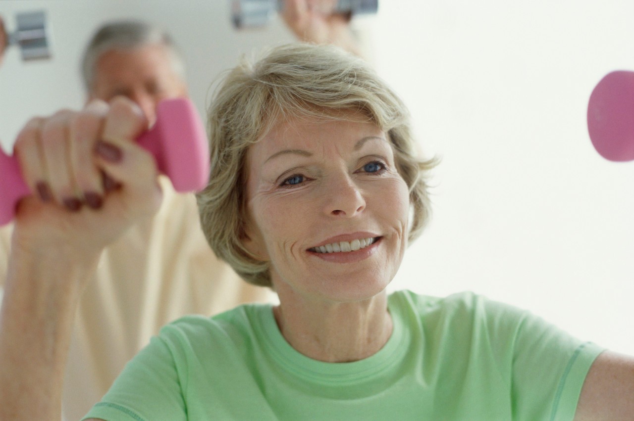 Senior couple exercising with dumbbells --- Image by © Michael A. Keller/Corbis