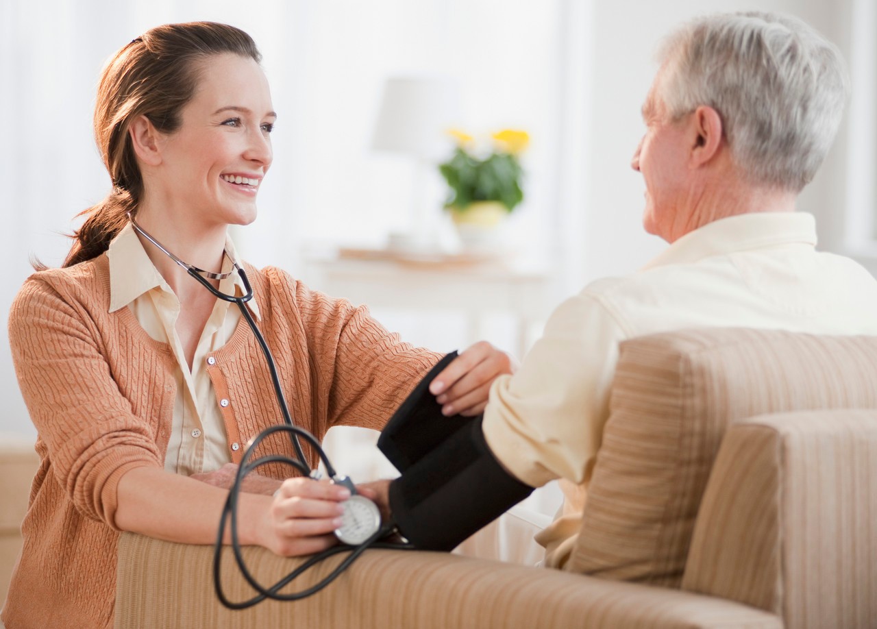 Nurse taking senior man's blood pressure --- Image by © Tetra Images/Corbis