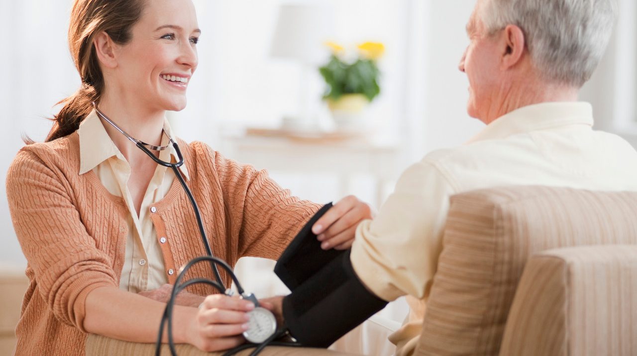 Nurse taking senior man's blood pressure --- Image by © Tetra Images/Corbis