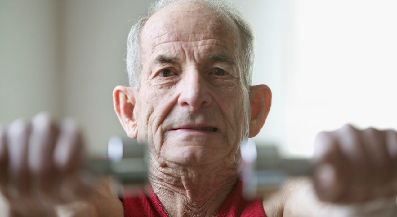 Portrait of elderly man lifting weights --- Image by © Jose Luis Pelaez, Inc./Blend Images/Corbis