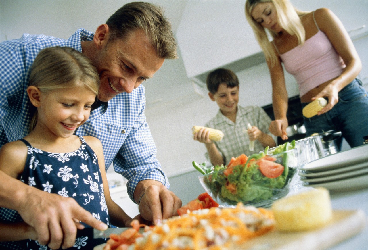 Family preparing the food, part of --- Image by © Alexander Scott/Corbis