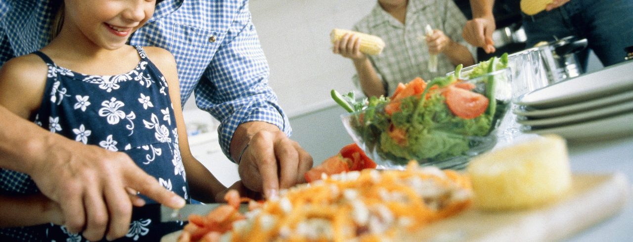 Family preparing the food, part of --- Image by © Alexander Scott/Corbis