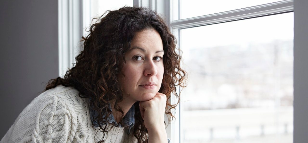 Portrait of woman thinking by window --- Image by © Darren Kemper/Corbis