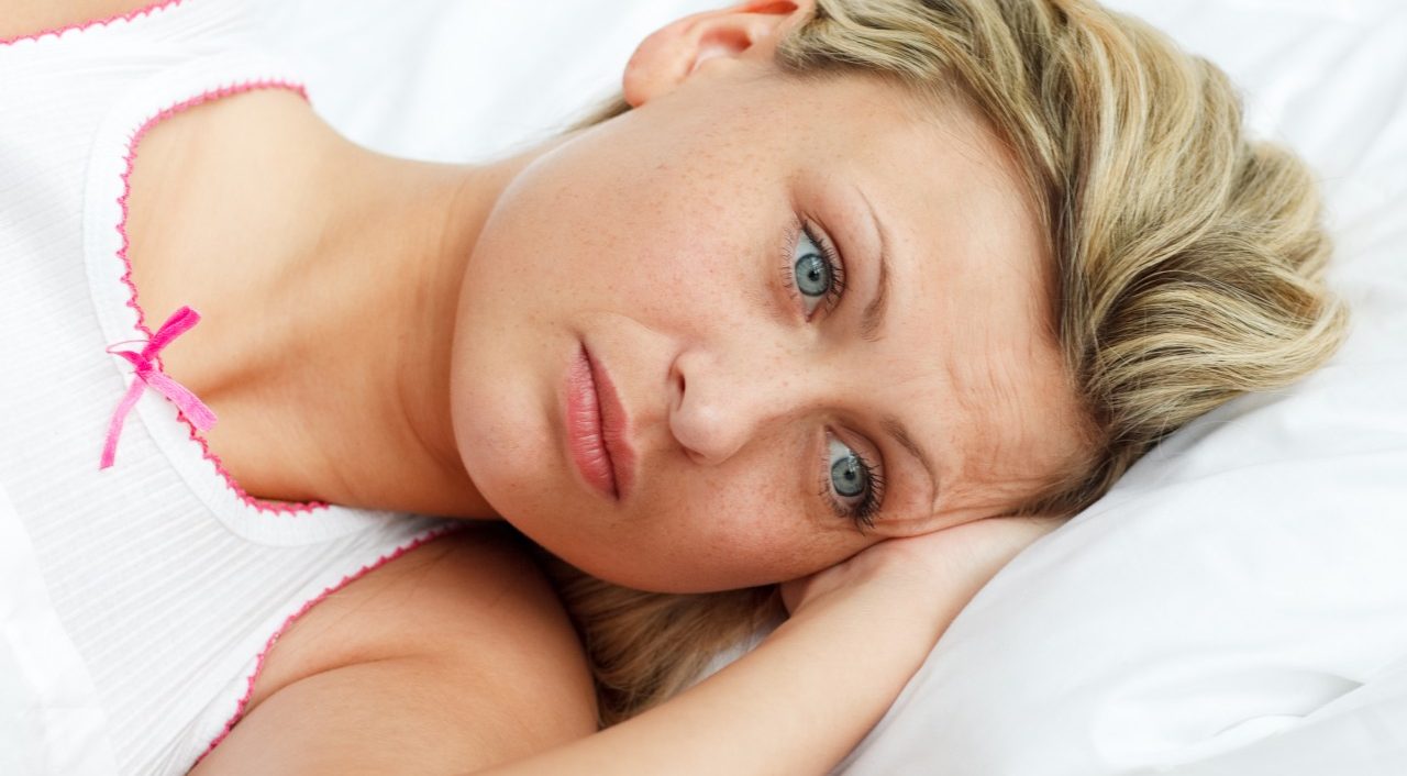 Portrait of upset woman lying in bed --- Image by © Wavebreak Media Ltd/Veer/Corbis