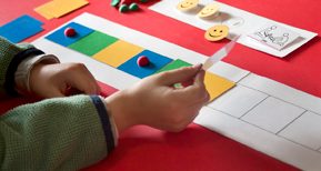 Autism therapy, Child placing colored squares in sequence on table.   Source: 85039_1_Thinkstock_105088879