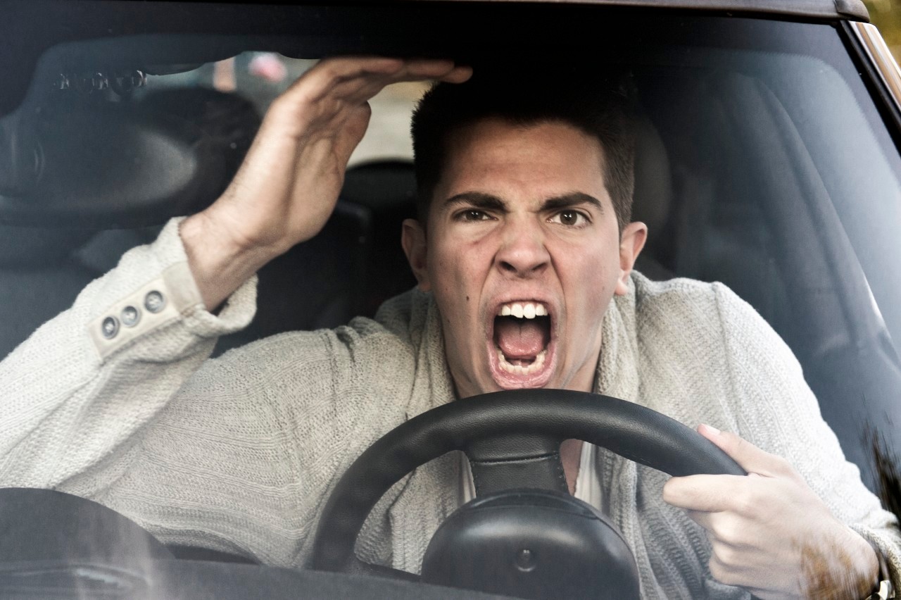 young man gets angry while driving the car --- Image by © Sandra Hoever/Corbis