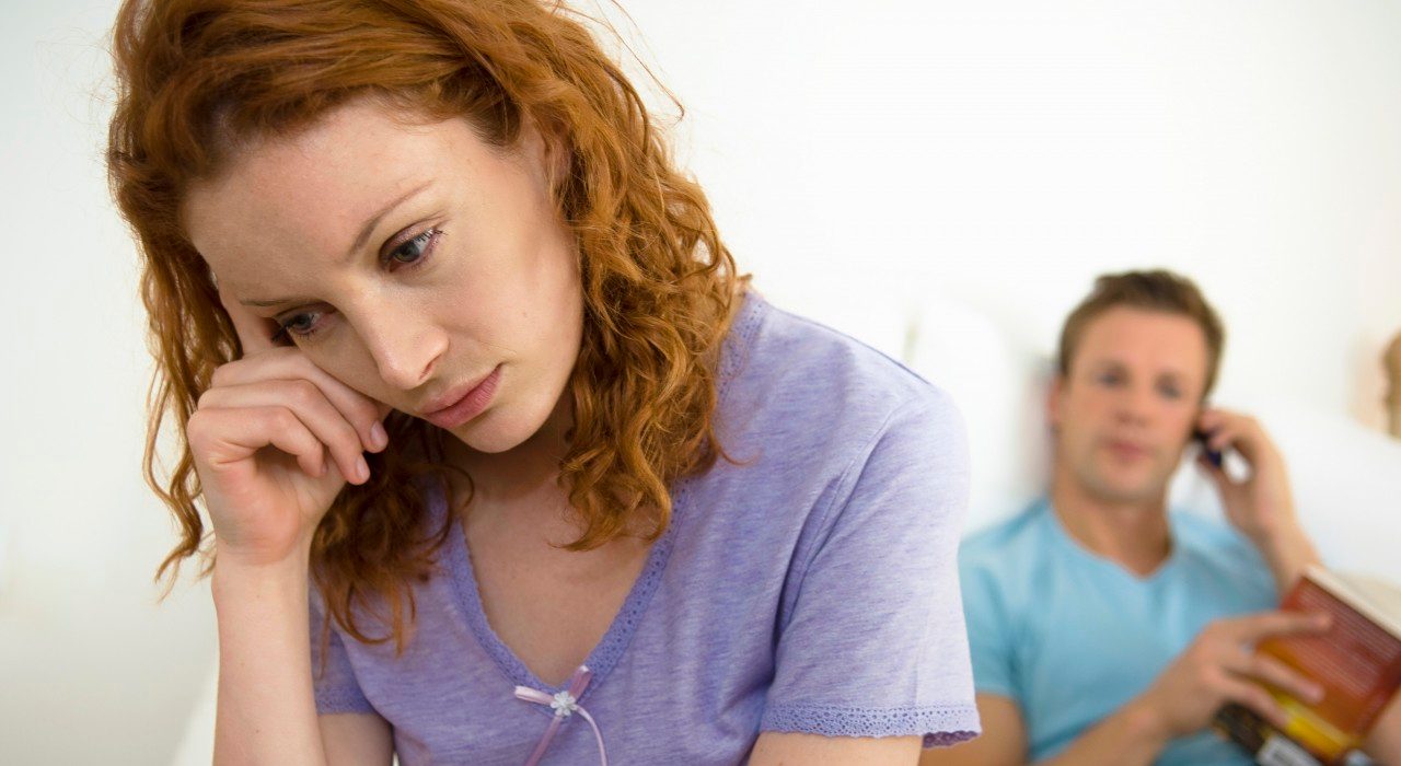 07 Jul 2005 --- Troubled woman, husband in background --- Image by © Simon Potter/Corbis