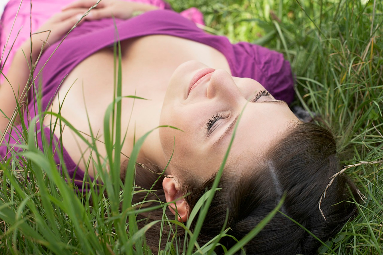 Woman napping in the grass --- Image by © Heide Benser/Corbis