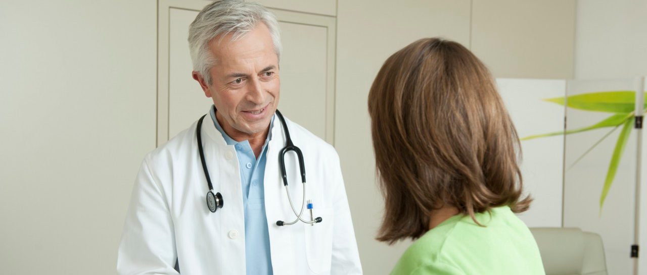 Doctor and female patient shaking hands --- Image by © Petrol/Corbis