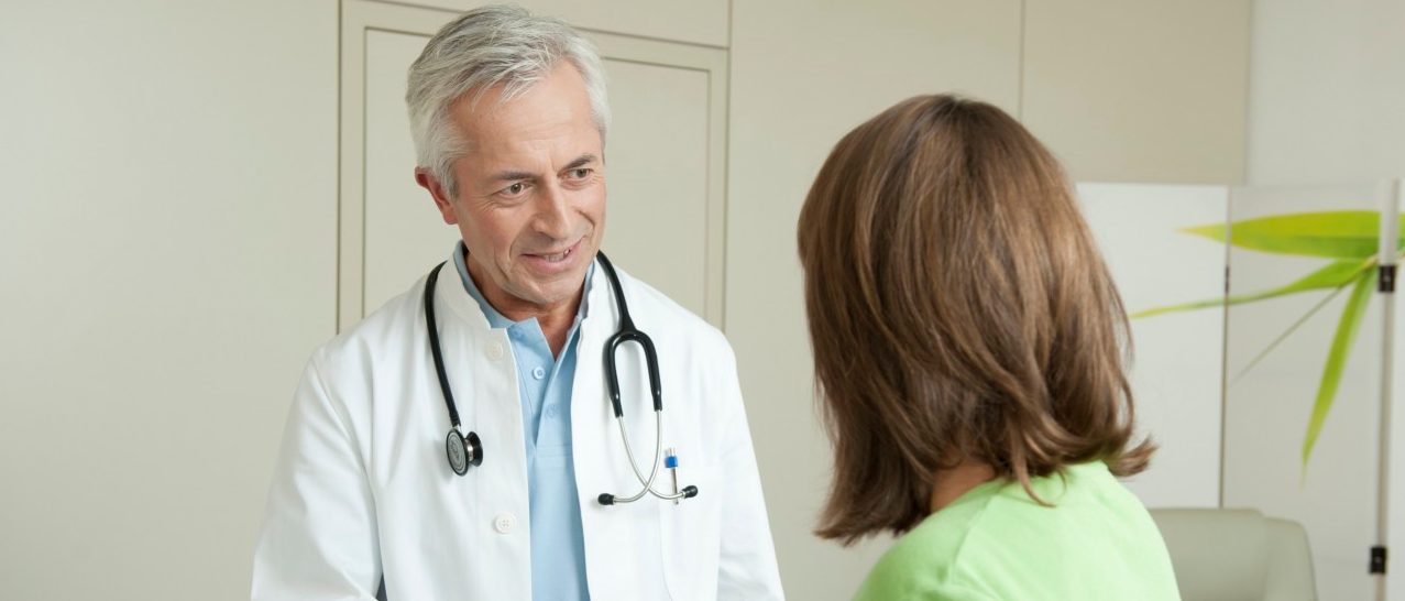 Doctor and female patient shaking hands --- Image by © Petrol/Corbis