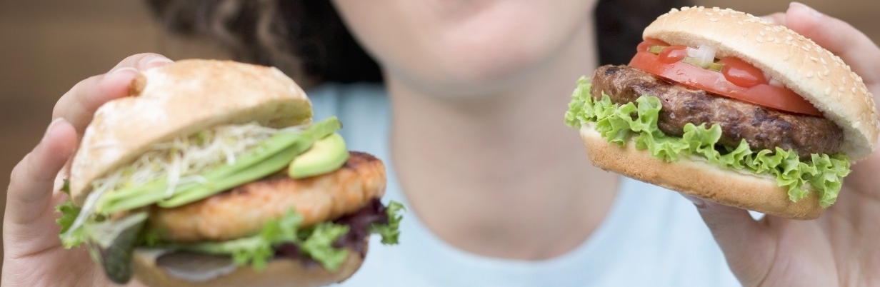 28 Feb 2008 --- Woman with two different burgers --- Image by © the food passionates/Corbis