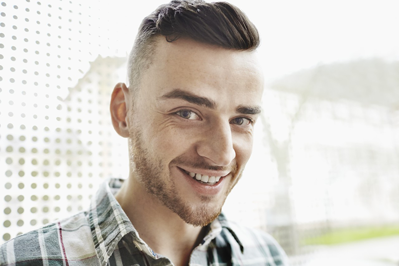 Portrait of smiling young man --- Image by © Oliver Rossi/Corbis