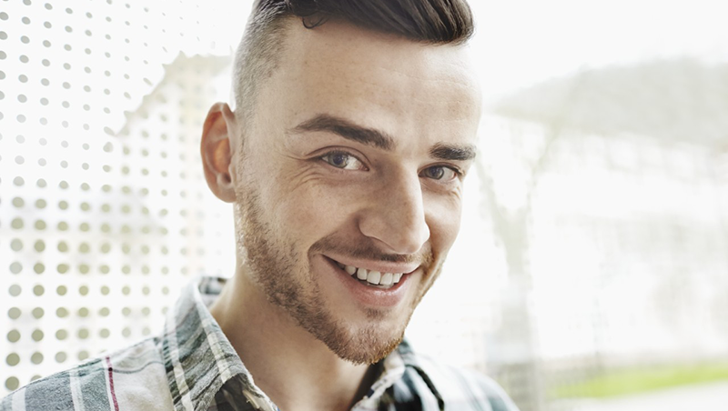 Portrait of smiling young man --- Image by © Oliver Rossi/Corbis