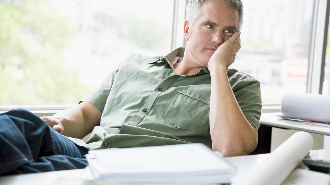 18 Jun 2012 --- Middle-aged office worker looking bored at desk. --- Image by © Hero Images/Corbis