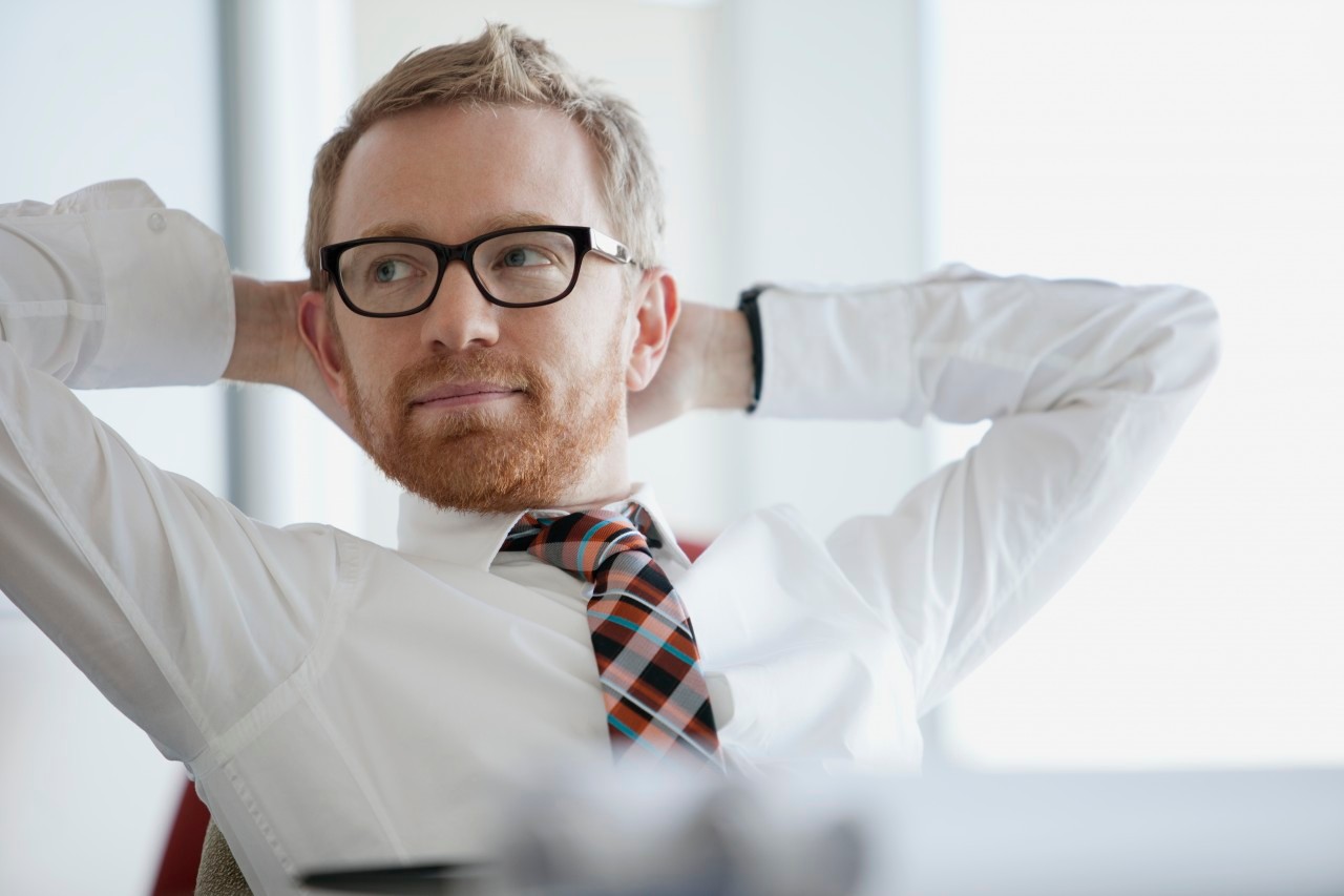 businessman with hands behind head --- Image by © Hero Images/Corbis