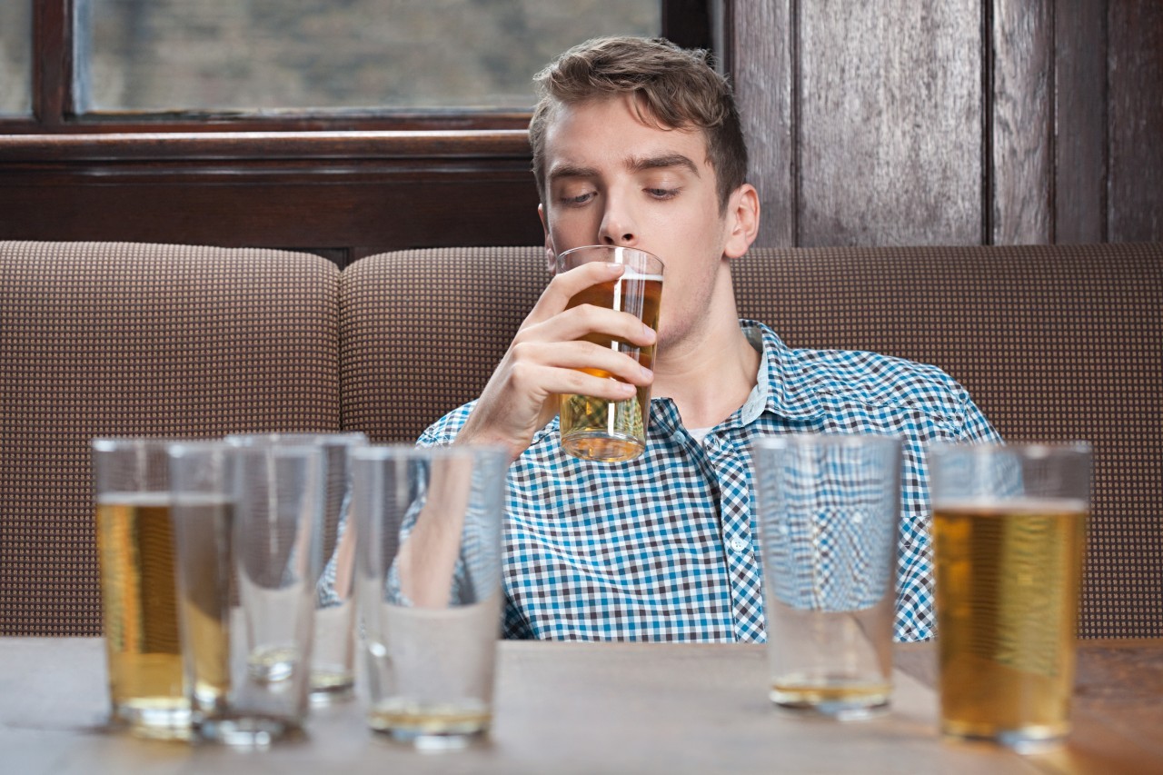 Young man drinking beer in bar --- Image by © Image Source/Corbis