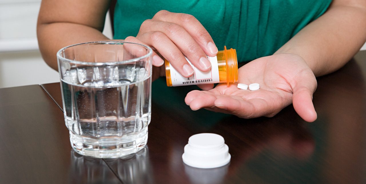 Woman Taking Tablets --- Image by © Image Source/Corbis