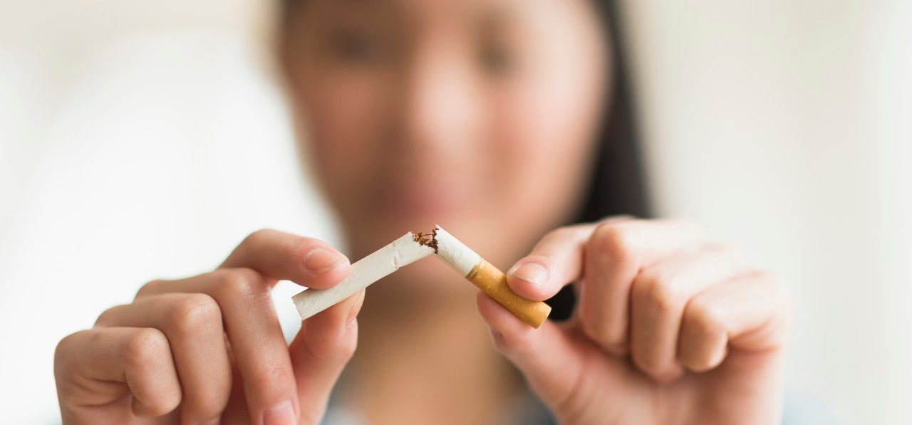 15 Apr 2014, Jersey City, New Jersey, USA --- Mixed race teenage girl breaking cigarette in half --- Image by © JGI/Tom Grill/Blend Images/Corbis