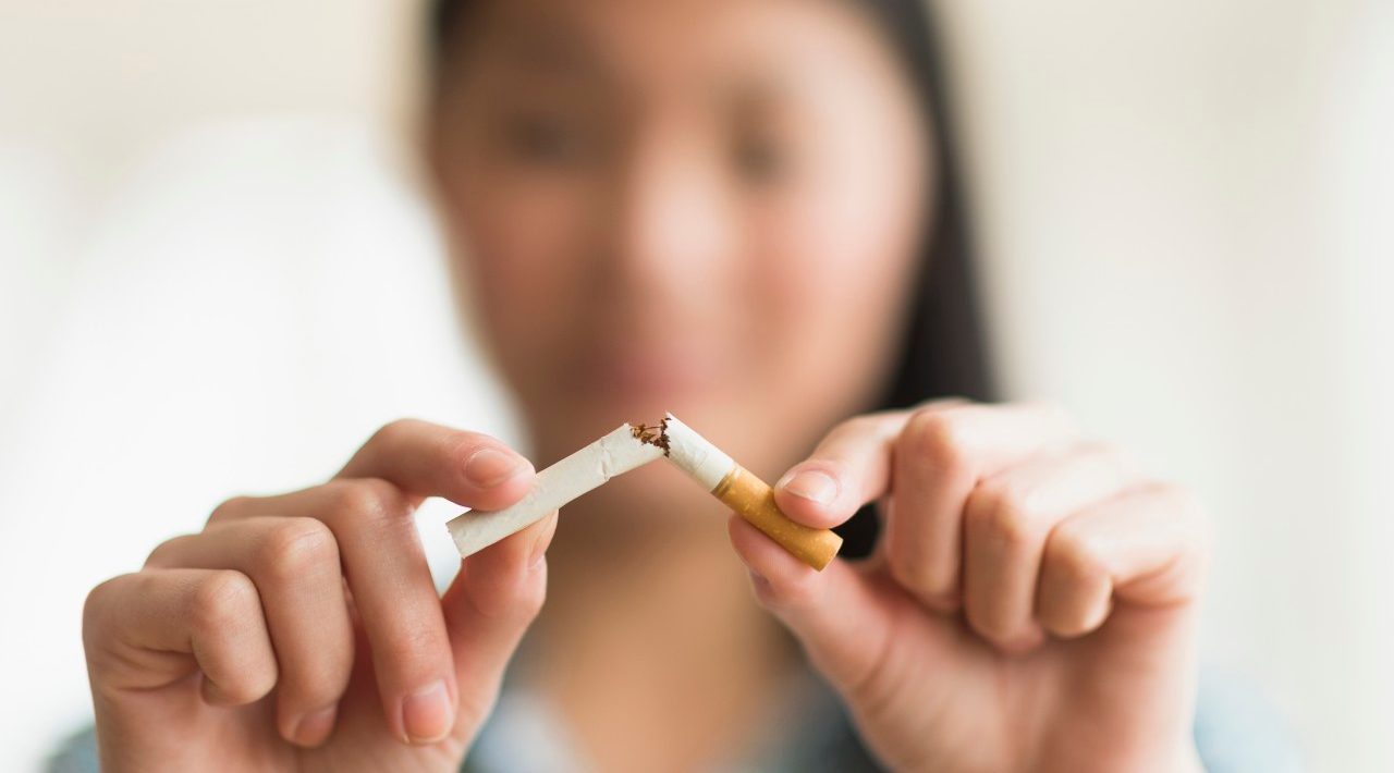 15 Apr 2014, Jersey City, New Jersey, USA --- Mixed race teenage girl breaking cigarette in half --- Image by © JGI/Tom Grill/Blend Images/Corbis