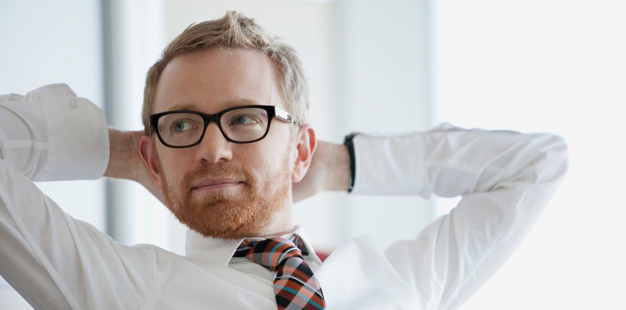 businessman with hands behind head --- Image by © Hero Images/Corbis