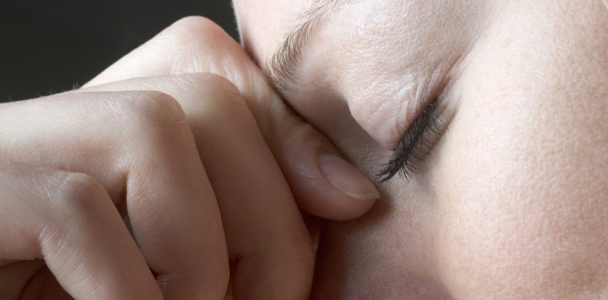 A Woman Squeezing the Bridge of Her Nose --- Image by © Vladimir Godnik/fstop/Corbis