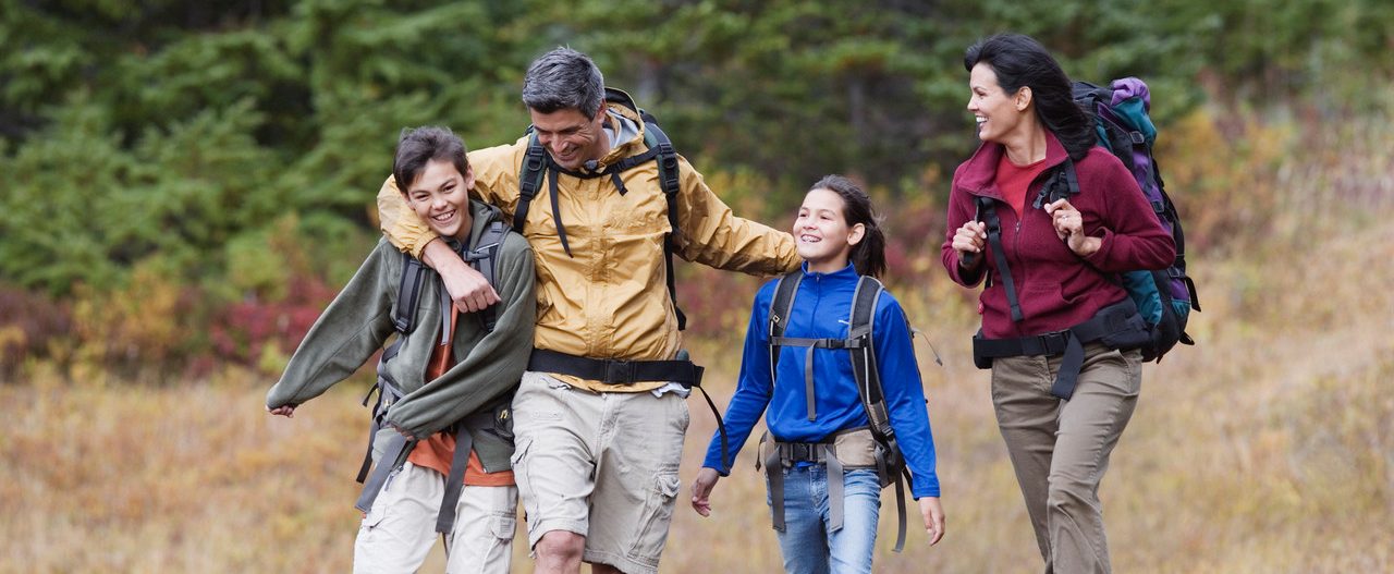 Family hiking through dry field --- Image by © Jeremy Woodhouse/Blend Images/Corbis