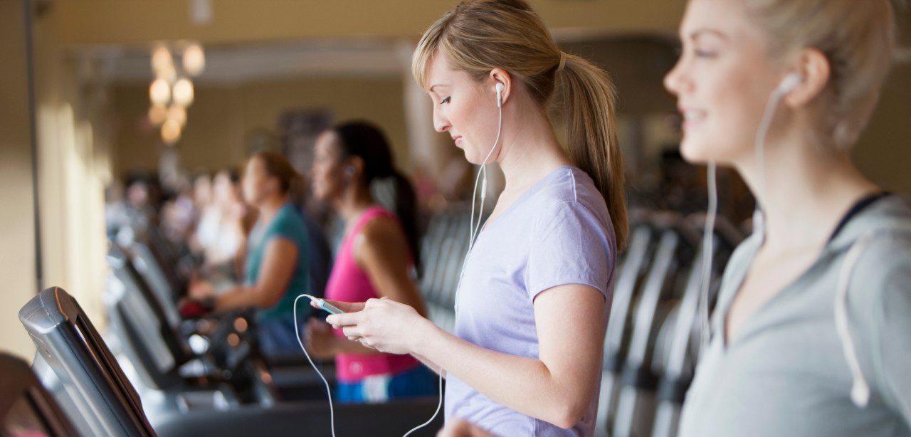 11 May 2012 --- Caucasian women using mp3 players on treadmills in gym --- Image by © Jose Luis Pelaez Inc/Blend Images/Corbis