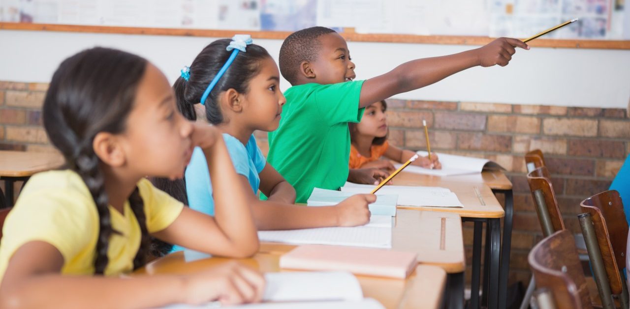 11 May 2014 --- Cute pupil raising hand in classroom --- Image by © Wavebreak Media LTD/Wavebreak Media Ltd./Corbis