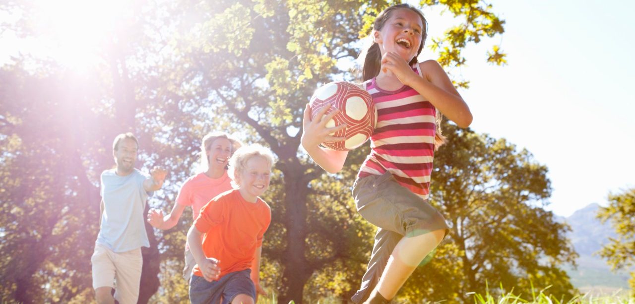 16 Sep 2014 --- Grandparents and grandchildren running with ball in rural field --- Image by © Ian Lishman/Juice Images/Corbis