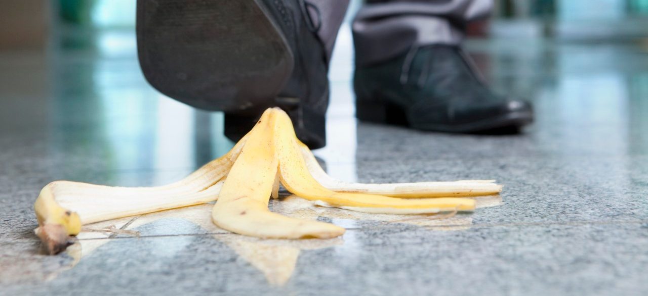 Businessman stepping on banana peel --- Image by © Juice Images/Corbis