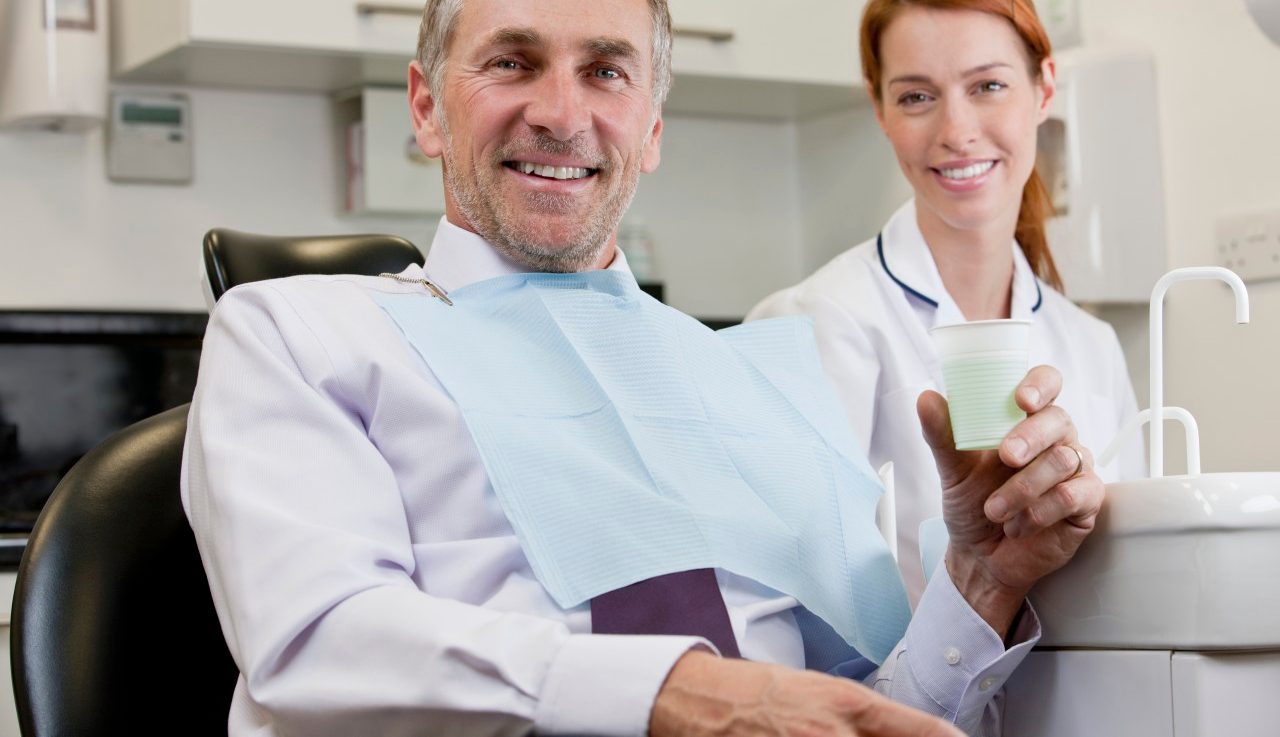 Male patient at the dentist, female dentist/hygienist looking on --- Image by © I Love Images/Corbis