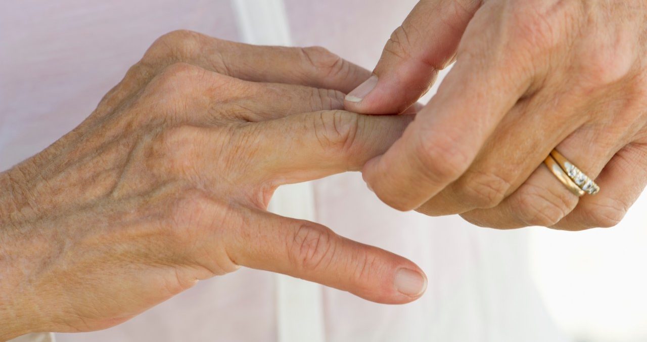 Senior woman rubbing knuckles, cropped --- Image by © Frederic Cirou/PhotoAlto/Corbis