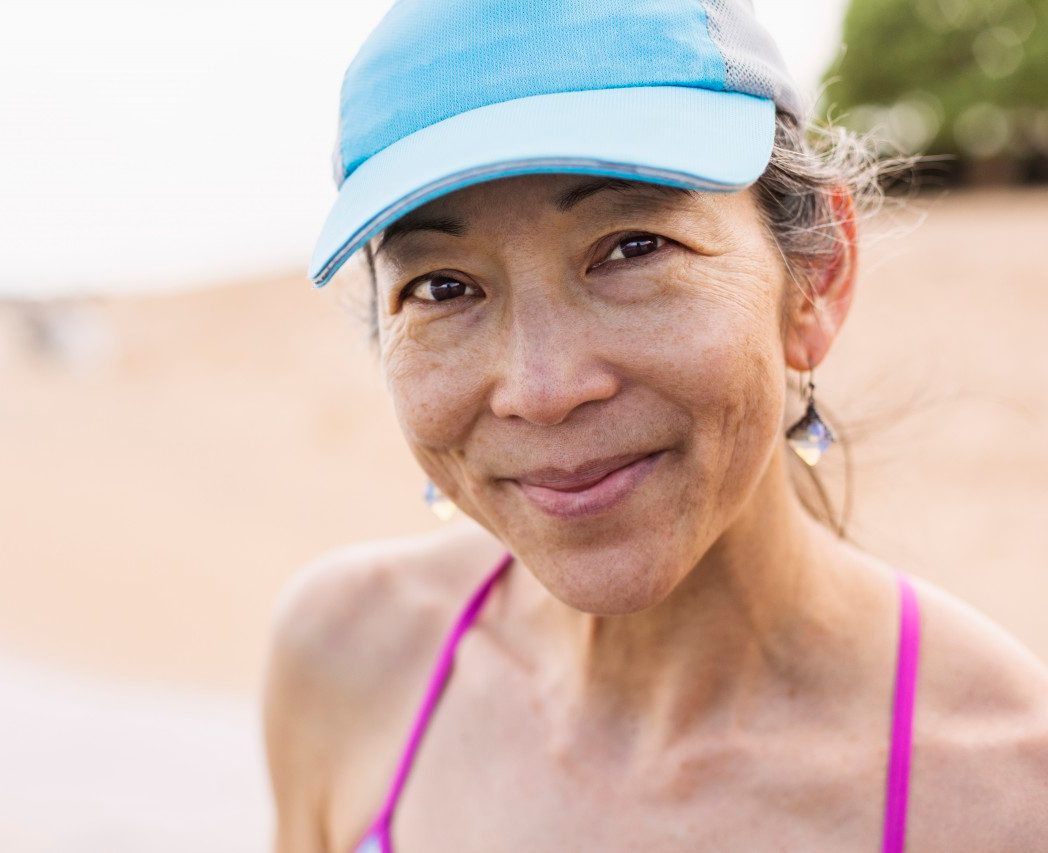 04 Apr 2014, Kauai, Hawaii, USA --- Japanese woman smiling on beach --- Image by © Don Mason/Blend Images/Corbis