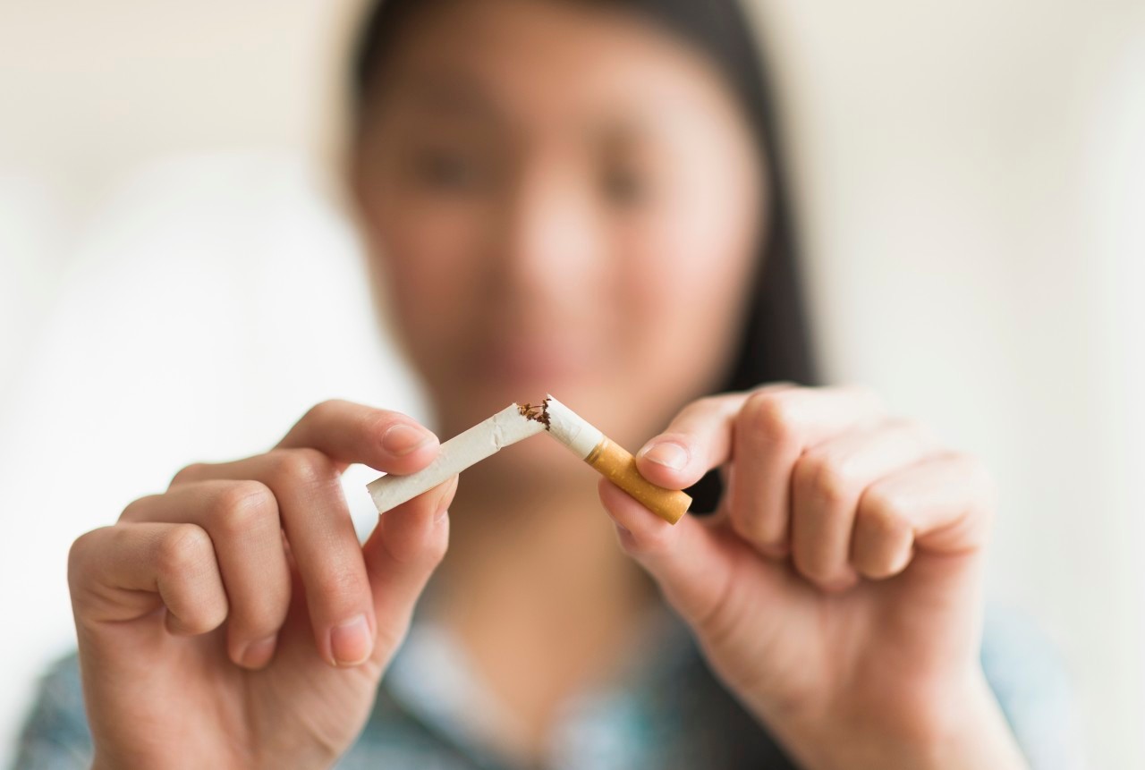 15 Apr 2014, Jersey City, New Jersey, USA --- Mixed race teenage girl breaking cigarette in half --- Image by © JGI/Tom Grill/Blend Images/Corbis