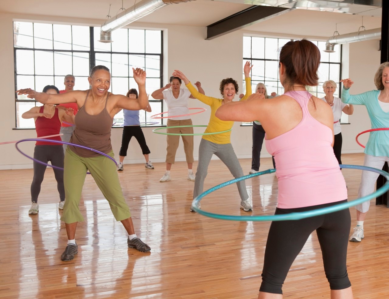 10 Apr 2011 --- Women spinning plastic hoops in fitness class --- Image by © Ariel Skelley/Blend Images/Corbis