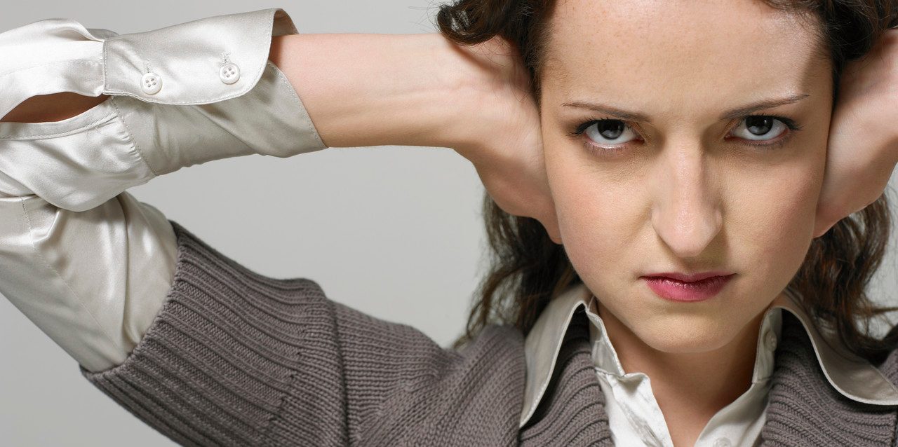 Businesswoman with hands over ears --- Image by © Beau Lark/Corbis