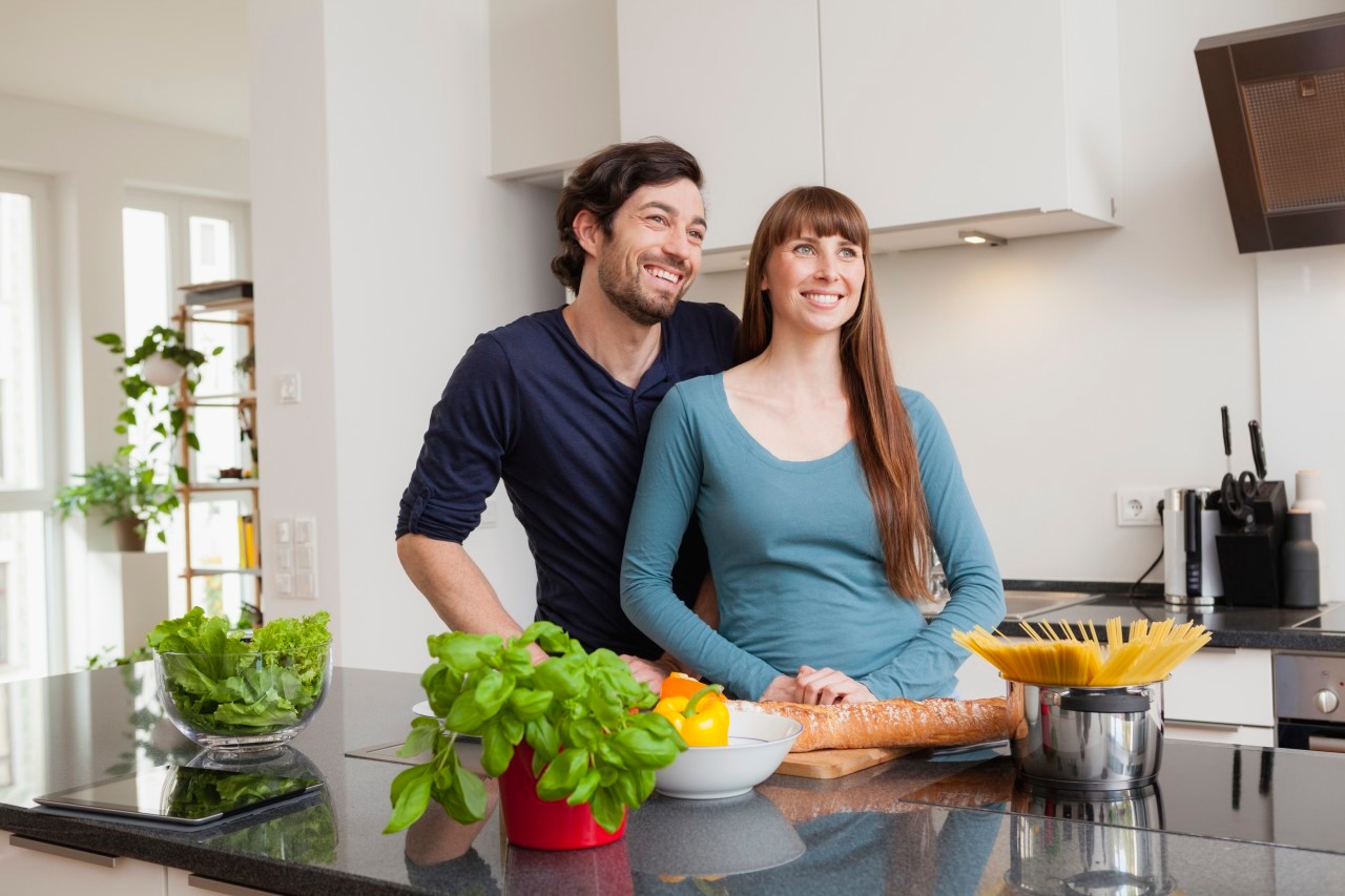 28 Oct 2014 --- Happy couple in kitchen --- Image by © Jo Kirchherr/Westend61/Corbis