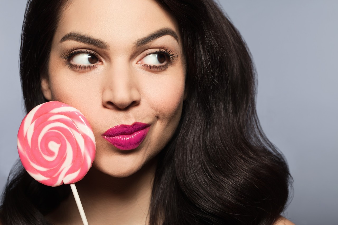 19 Nov 2014 --- Mid adult woman holding pink lollipop --- Image by © Corina Marie Howell/Corbis